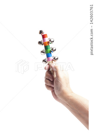 Hand holding colorful wooden bell for children. Hand holding colorful wooden bell for children. 142603761