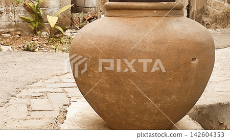 Traditional Clay Water Jar Outside a Rustic Village Alley Traditional Clay Water Jar Outside a Rustic Village Alley 142604353