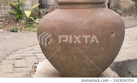 Traditional Clay Water Jar Outside a Rustic Village Alley Traditional Clay Water Jar Outside a Rustic Village Alley 142604354