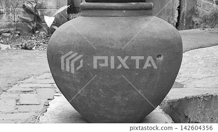 Monochrome View of a Traditional Clay Water Jar in a Rural Alley Monochrome View of a Traditional Clay Water Jar in a Rural Alley 142604356