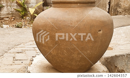 Traditional Clay Water Jar Outside a Rustic Village Alley Traditional Clay Water Jar Outside a Rustic Village Alley 142604357