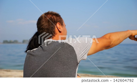 Happy pair hugs during sitting on wooden log on beach. Romantic couple admiring sea landscape at sunny day. Lovers spending time together at resort. Concept of summer vacation or holiday. Slow mo Happy pair hugs during sitting on wooden log on beach. Romantic couple admiring sea landscape at sunny day. Lovers spending time together at resort. Concept of summer vacation or holiday. Slow mo 142604792