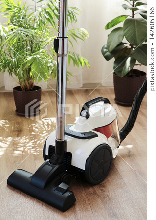 Cleaning the floor with a vacuum cleaner. Vertical photo Cleaning the floor with a vacuum cleaner. Vertical photo 142605166