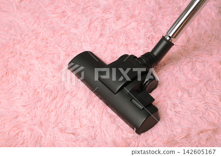 Cleaning the carpet with a vacuum cleaner Cleaning the carpet with a vacuum cleaner 142605167