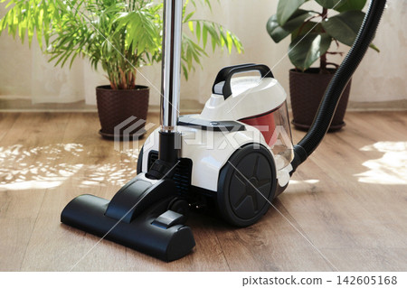 Cleaning the floor with a vacuum cleaner Cleaning the floor with a vacuum cleaner 142605168