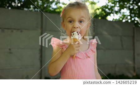 Portrait of cute blonde girl eating delicious ice cream in a waffle cone outdoor. Beautiful small child enjoying a sweet cold dessert in a summer garden. Innocent little kid tasting refreshing food Portrait of cute blonde girl eating delicious ice cream in a waffle cone outdoor. Beautiful small child enjoying a sweet cold dessert in a summer garden. Innocent little kid tasting refreshing food 142605219