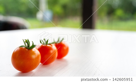 Fresh cherry tomatoes lined on white tabletop with soft garden background, bright natural daylight, minimal food composition, shallow depth of field, healthy organic produce, summer freshness, clean Fresh cherry tomatoes lined on white tabletop with soft garden background, bright natural daylight, minimal food composition, shallow depth of field, healthy organic produce, summer freshness, clean 142605951