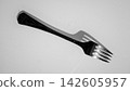 Black plastic serving fork with five tines, diagonal close view on clean white background, glossy handle detail for dining, catering, kitchen, and food service concepts 142605957