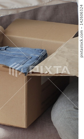 Vertical video. Unboxing Online Shop Purchase: Woman Opening Parcel at Home. 142606324