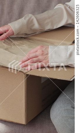 Vertical video. Unboxing Online Shop Purchase: Woman Opening Parcel at Home. Vertical video. Unboxing Online Shop Purchase: Woman Opening Parcel at Home. 142606325