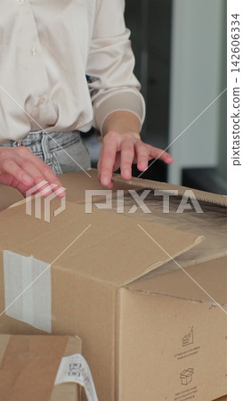Vertical video. Unboxing Online Shop Purchase: Woman Opening Parcel Box at Home. Vertical video. Unboxing Online Shop Purchase: Woman Opening Parcel Box at Home. 142606334