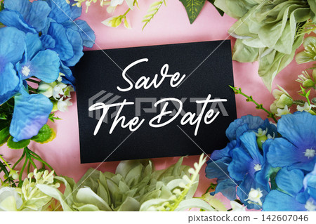 Save The Date text written on paper card with flowers decoration Save The Date text written on paper card with flowers decoration 142607046