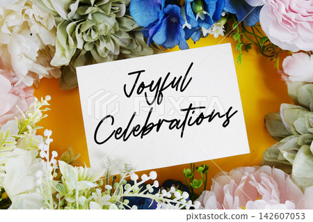 Joyful Celebrations text written on paper card with flowers decoration Joyful Celebrations text written on paper card with flowers decoration 142607053