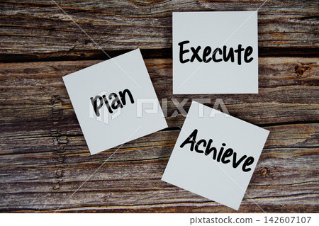 Plan, Execute, Achieve message on paper note flat lay on wooden background 142607107