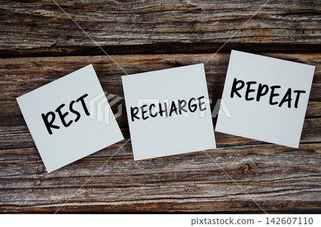 Rest, Recharge, Repeat message on paper note flat lay on wooden background Rest, Recharge, Repeat message on paper note flat lay on wooden background 142607110