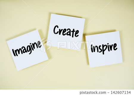 Imagine, Create, Inspire message on paper note flat lay on yellow background Imagine, Create, Inspire message on paper note flat lay on yellow background 142607134