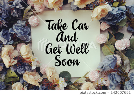Take Care And Get Well Soon text with flower decoration on wooden background Take Care And Get Well Soon text with flower decoration on wooden background 142607691