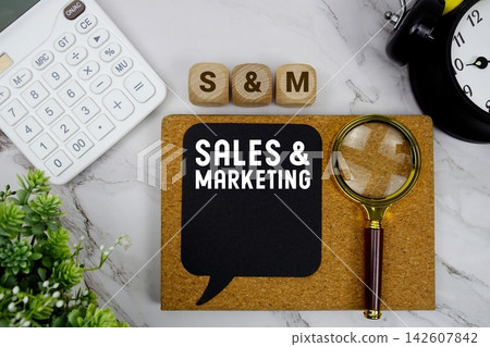 S&M Sales & Marketing text with calculator, magnifying glass and alarm clock on marble background S&M Sales & Marketing text with calculator, magnifying glass and alarm clock on marble background 142607842