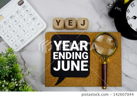 YEJ Year Ending June text with calculator, magnifying glass and alarm clock on marble background YEJ Year Ending June text with calculator, magnifying glass and alarm clock on marble background 142607844