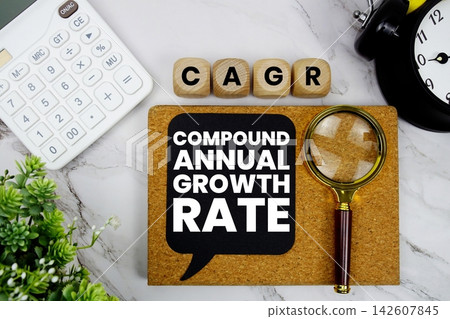 CAGR Compound Annual Growth Rate text with calculator, magnifying glass and alarm clock on marble background CAGR Compound Annual Growth Rate text with calculator, magnifying glass and alarm clock on marble background 142607845