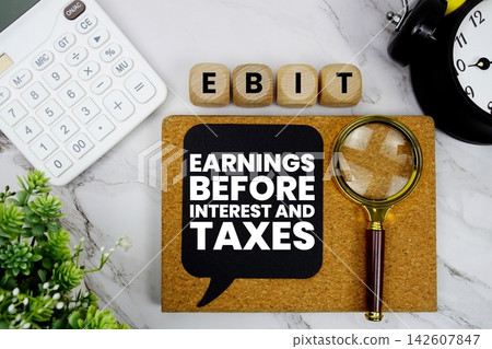 EBIT Earnings Before Interest and Taxes text with calculator, magnifying glass and alarm clock on marble background EBIT Earnings Before Interest and Taxes text with calculator, magnifying glass and alarm clock on marble background 142607847