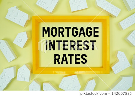 Mortgage Interest Rates text with house models on yellow background 142607885