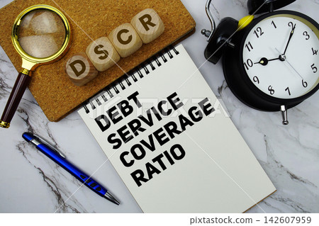 DSCR Debt Service Coverage Ratio text written on notepad with calculator and magnifying glass on marble background DSCR Debt Service Coverage Ratio text written on notepad with calculator and magnifying glass on marble background 142607959