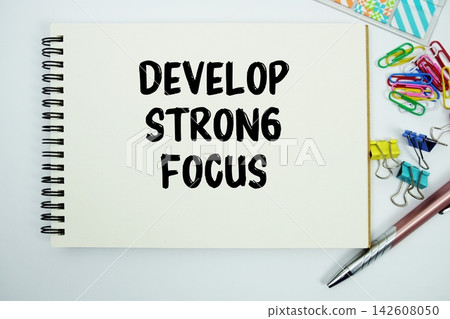 Develop Strong Focus text message written on notepad with stationery flat lay on white background Develop Strong Focus text message written on notepad with stationery flat lay on white background 142608050