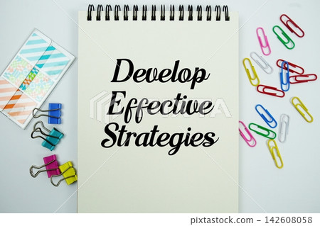 Develop Effective Strategies text message written on notepad with stationery flat lay on white background Develop Effective Strategies text message written on notepad with stationery flat lay on white background 142608058