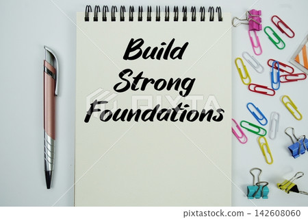Build Strong Foundations text message written on notepad with stationery flat lay on white background Build Strong Foundations text message written on notepad with stationery flat lay on white background 142608060