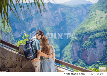 Couple travelers standing together at Sumidero Canyon viewpoint in Chiapas Mexico with steep canyon walls lush landscape river overlook nature tourism and enjoying a scenic overlook. Couple travelers standing together at Sumidero Canyon viewpoint in Chiapas Mexico with steep canyon walls lush landscape river overlook nature tourism and enjoying a scenic overlook. 142608395