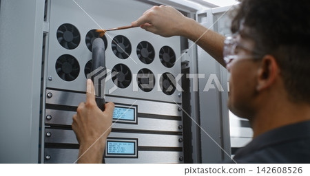 Male Technician Dusting Server Cabinet Ventilation Fans with Vacuum Hose Male Technician Dusting Server Cabinet Ventilation Fans with Vacuum Hose 142608526