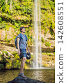 Man traveler standing by Marisol A waterfall in lush green jungle in Chiapas Mexico with tropical water rocks forest ecotourism destination adventure travel and smiling. 142608551