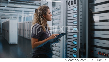 Female IT Specialist Using Digital Tablet near Open Server Cabinet Female IT Specialist Using Digital Tablet near Open Server Cabinet 142608564