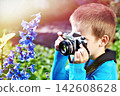 Boy with retro camera and flowers 142608628