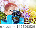 Boy with retro SLR camera shooting flower 142608629