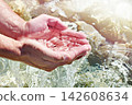 Hands and sea water 142608634