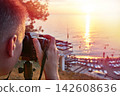 Photographer takes photos of beautiful sunset 142608636