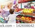 Mother and child with bell pepper in shop 142608642