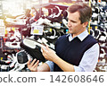 Man chooses hockey skates in shop 142608646