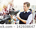 Man chooses hockey skates in shop 142608647