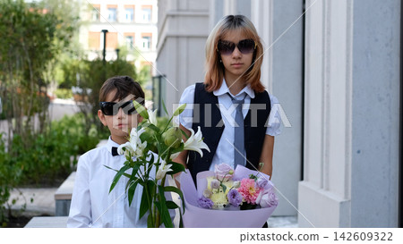 Schoolchildren Wearing Sunglasses with Flower Bouquets on September 1, Back to School, Knowledge Day, Student Friendship, School Fashion and New Academic Year Schoolchildren Wearing Sunglasses with Flower Bouquets on September 1, Back to School, Knowledge Day, Student Friendship, School Fashion and New Academic Year 142609322