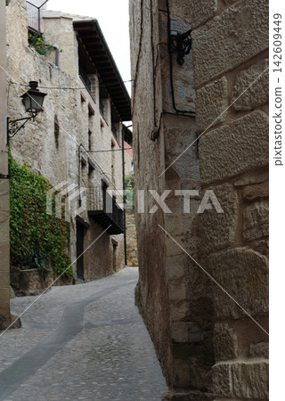 Ancient alleyway with stone walls, ivy, and lanterns Ancient alleyway with stone walls, ivy, and lanterns 142609449