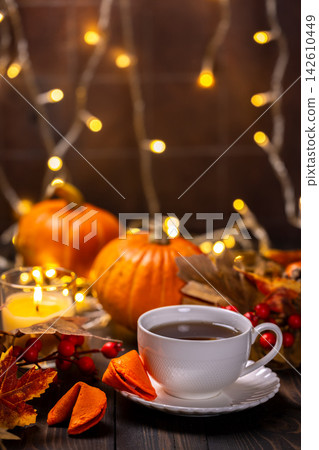 Warm tea cup on table with pumpkins and autumn decorations Warm tea cup on table with pumpkins and autumn decorations 142610449