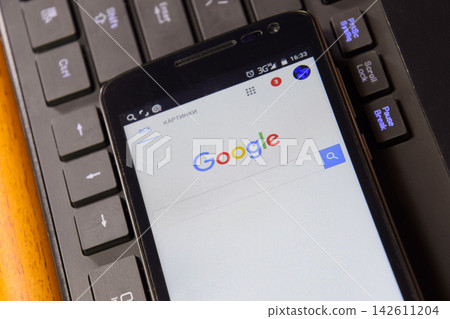 Smartphone with Google search system on the keyboard background. Smartphone with Google search system on the keyboard background. 142611204