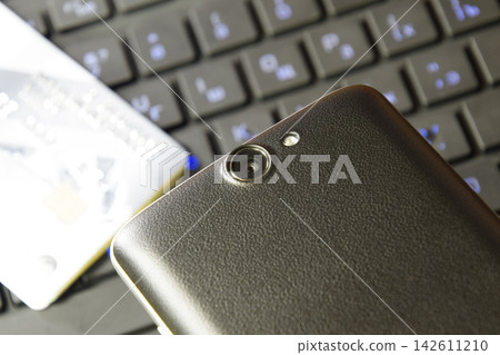 The smartphone with a camera on the background of your computer The smartphone with a camera on the background of your computer 142611210