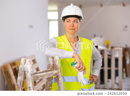 Portrait of positive woman builder during repair works 142612030