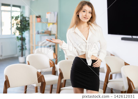 Young woman secretary invites to lecture hall Young woman secretary invites to lecture hall 142612031