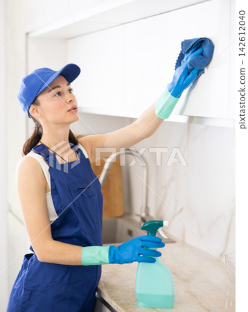 young positive girl is cleaning kitchen young positive girl is cleaning kitchen 142612040