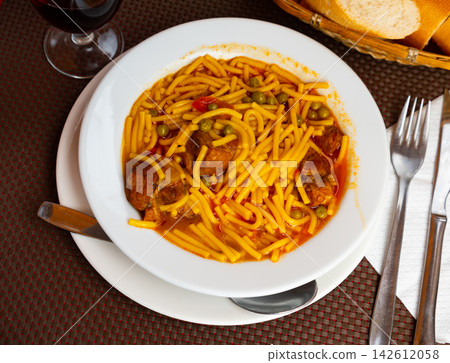 Soup with noodles and ribs. Traditional spanish dish closeup Soup with noodles and ribs. Traditional spanish dish closeup 142612058